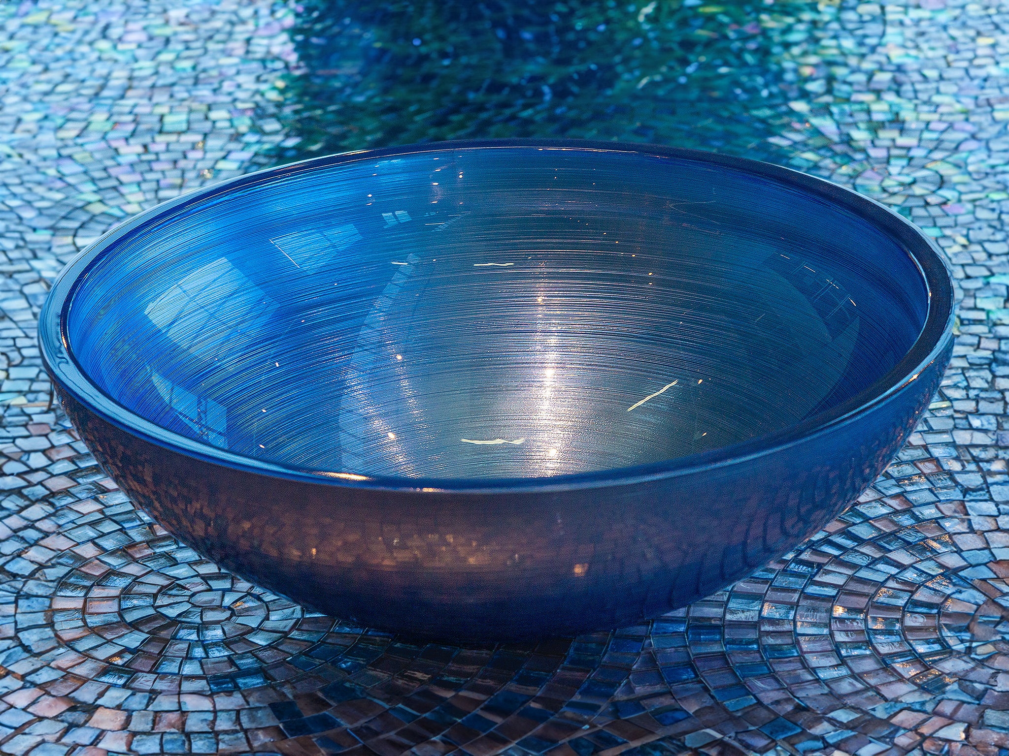 Ein Schmuckstück für Ihr Bad: Das Aufsatzwaschbecken "Doh" aus Glas, rund und in Blau. Ein perfektes Design-Waschbecken mit feiner Rillentextur. Aus italienischer Handwerkskunst entsteht dieses funkelnde farbige Glaswaschbecken. Auf Wunsch gibt es die passenden Mosaike als Untergrund. Jetzt im Tiamont Shop.