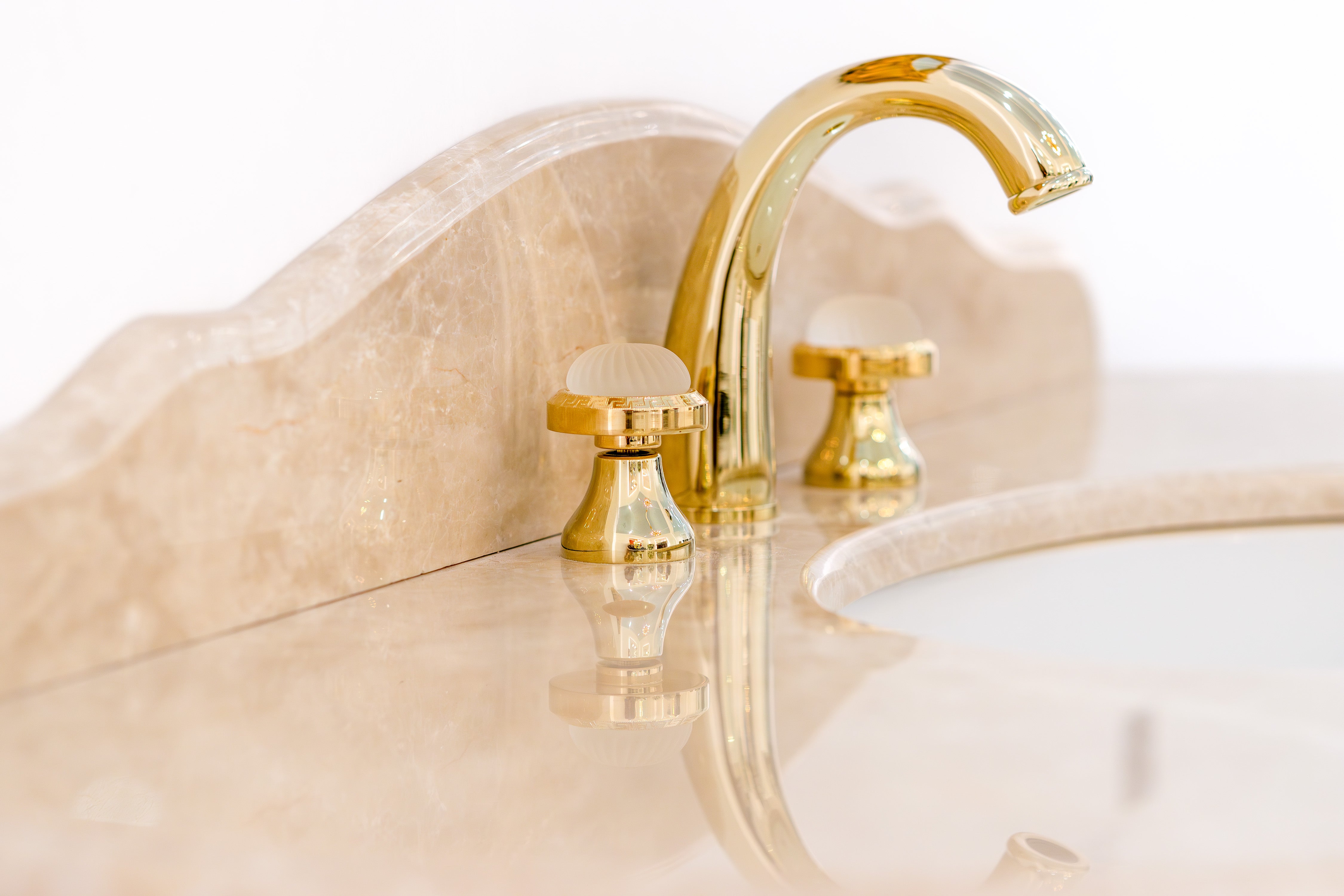 Die zarten Beigetöne haben eine beruhigende Wirkung. Edler Waschtisch mit Marmorplatte in Beige, kombiniert mit einem goldenen Waschbecken, perfekt für luxuriöse Badezimmerdesigns. Edle Badmöbel? Tiamont.