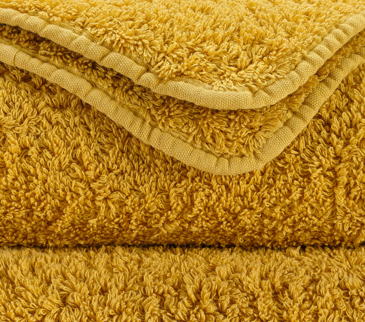 Premium-Handtuch-Set aus feinster Giza 70 Baumwolle in Gold – luxuriöses Badtextil von Tiamont, passend zu edlen Badmöbeln und stilvollen Interieurs. Handgefertigt in Portugal.