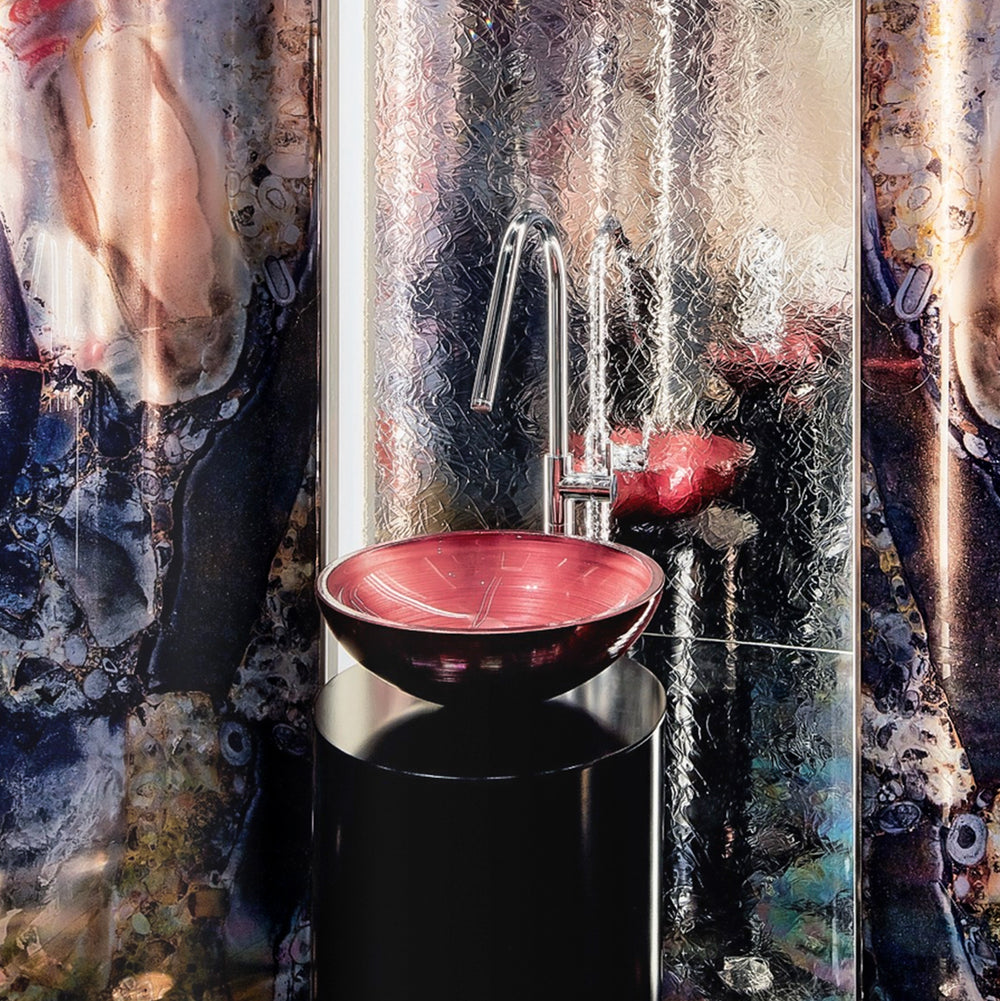 Elegant bathroom with a rosé SICIS® glass washbasin on a black pedestal in front of an opulent design wall – bathroom inspiration by Tiamont