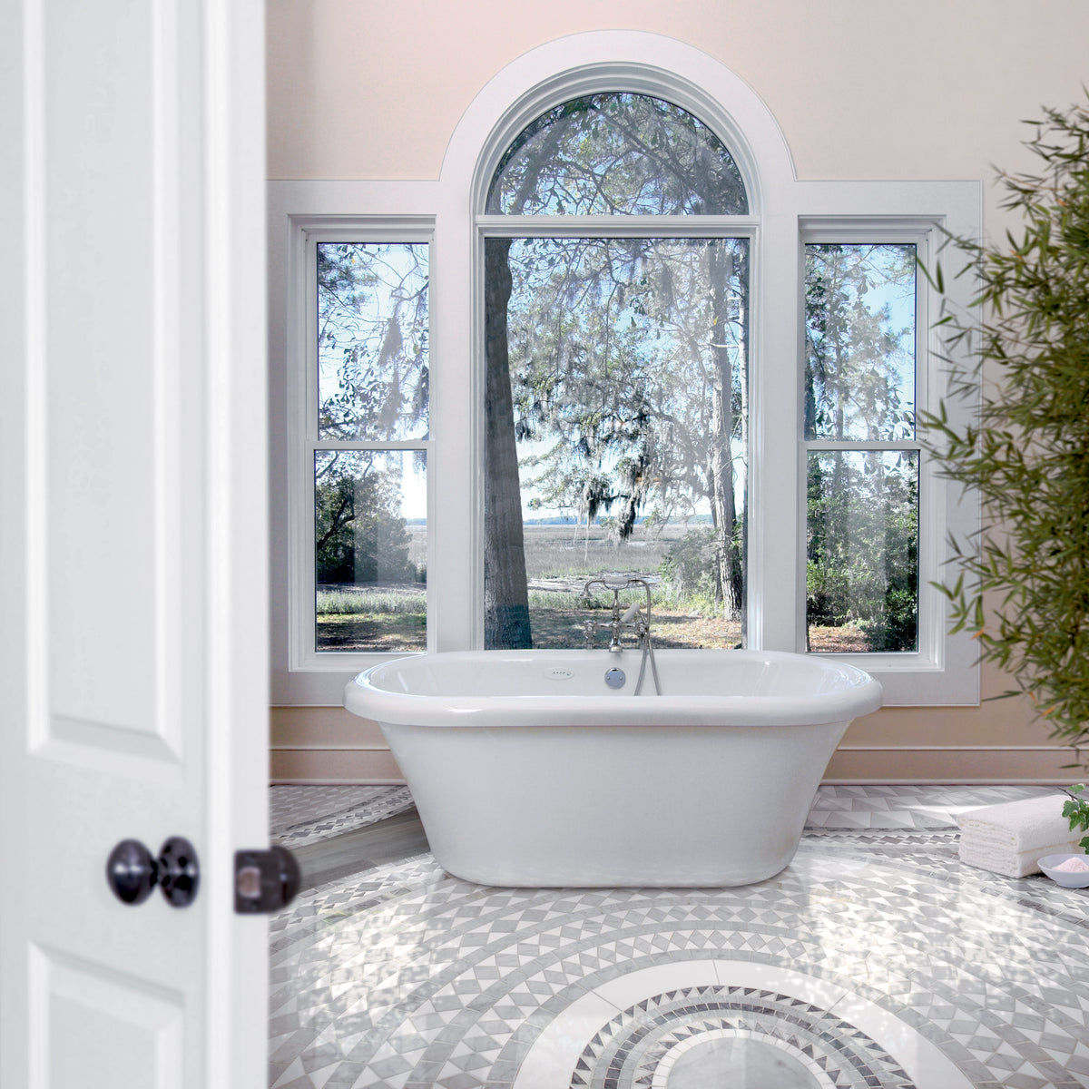 Bright bathroom with freestanding bath and an ornamental grey-and-white marble mosaic floor