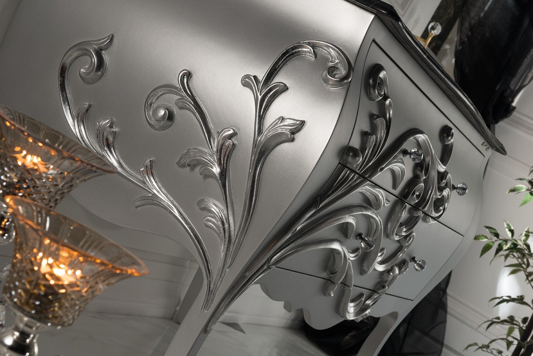 Extravaganter Waschtisch in Silber mit feinster Marmorplatte in Schwarz. Ein florales Dekor verziert die Fronten. Edle Badmöbel? Tiamont.